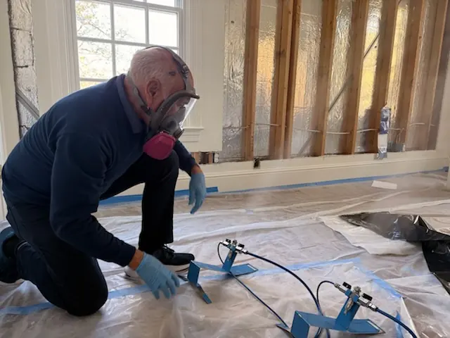A restoration technician setting drying equipment in a Denton home stripped to the studs