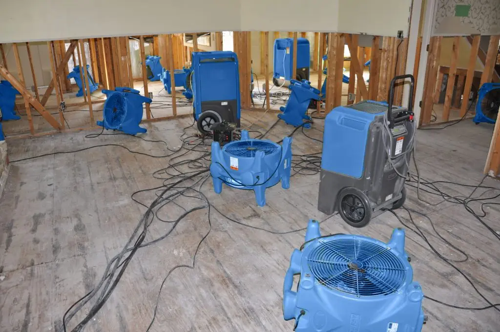 Air movers drying a gutted Denton room after major water damage